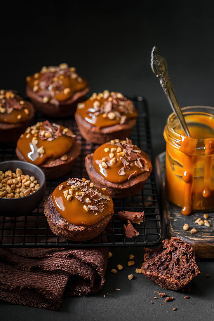 Schoko-Cupcakes mit Karamell-Topping, Schokoladenspänen und Nüssen