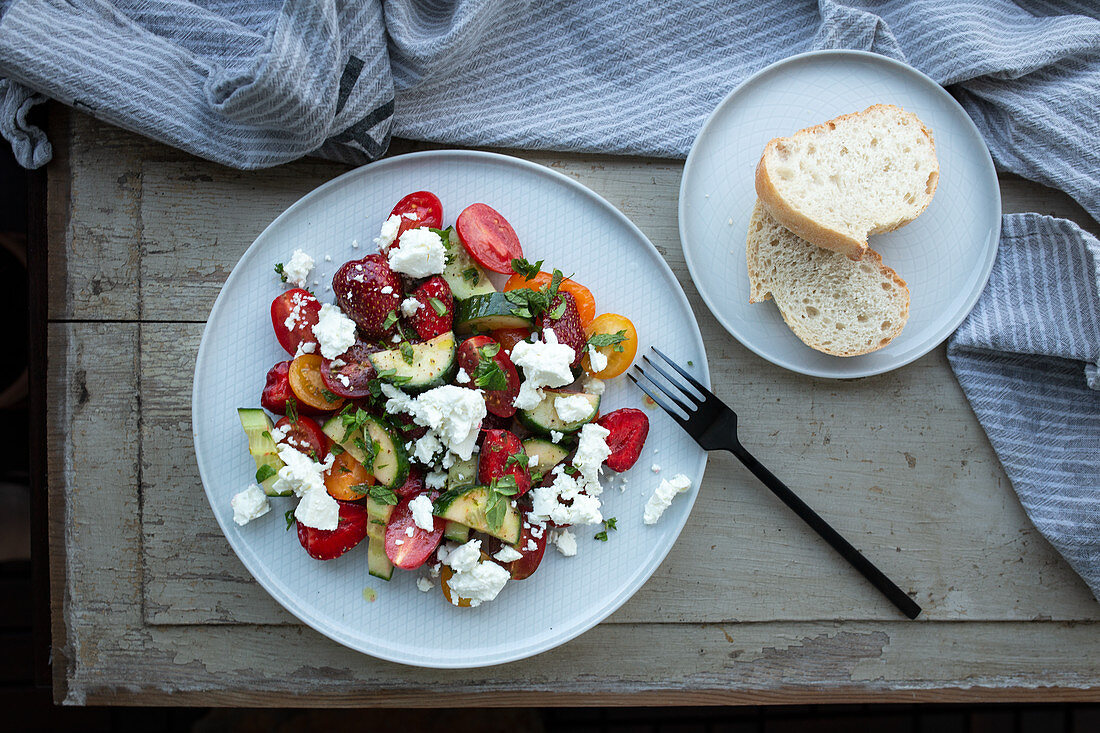 Strawberry salad with cucumber, tomatoes, sheep’s cheese and herbs
