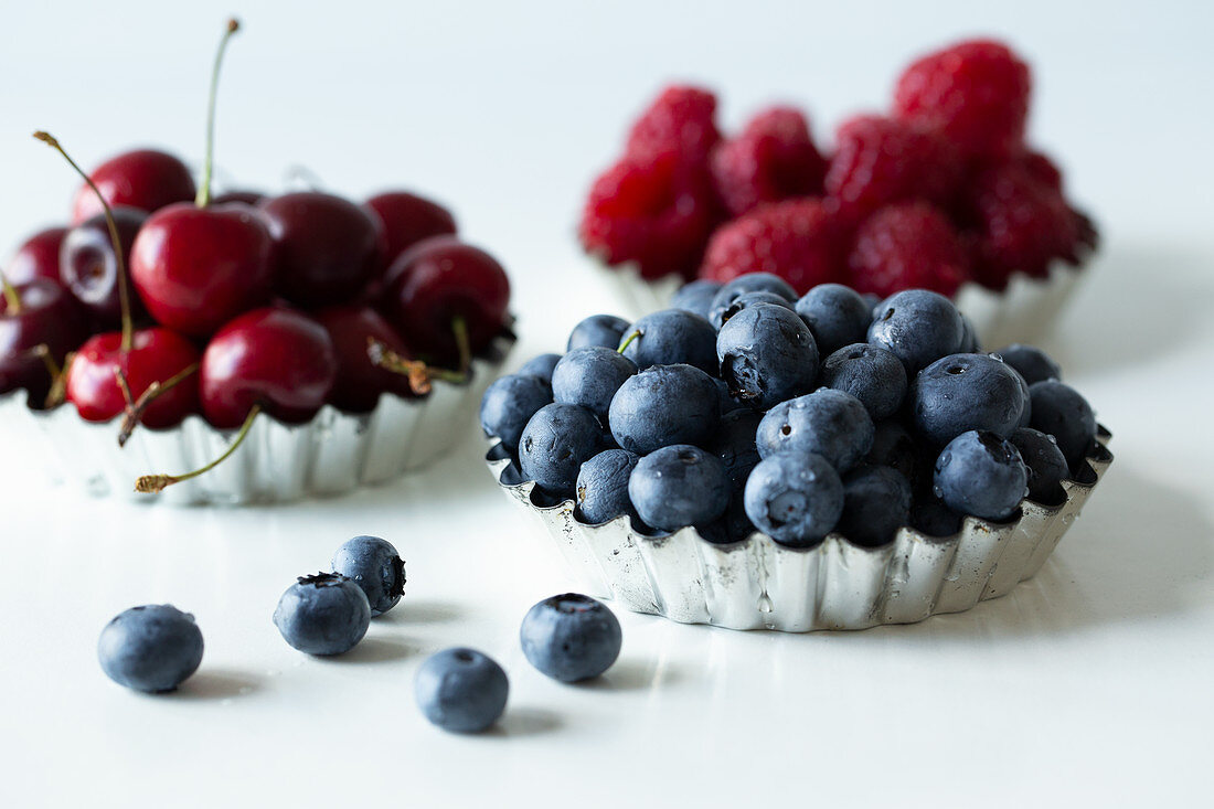 Tart cases with cherries, blueberries and raspberries