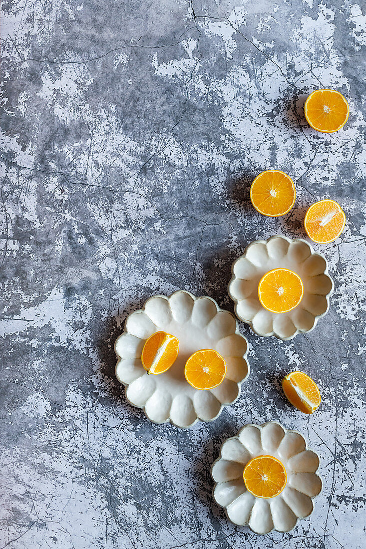 Geschnittene Orangen auf dekorativen Keramiktellern