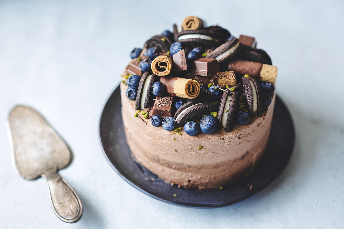Chocolate cake decorated with blueberries, chocolate and cookies