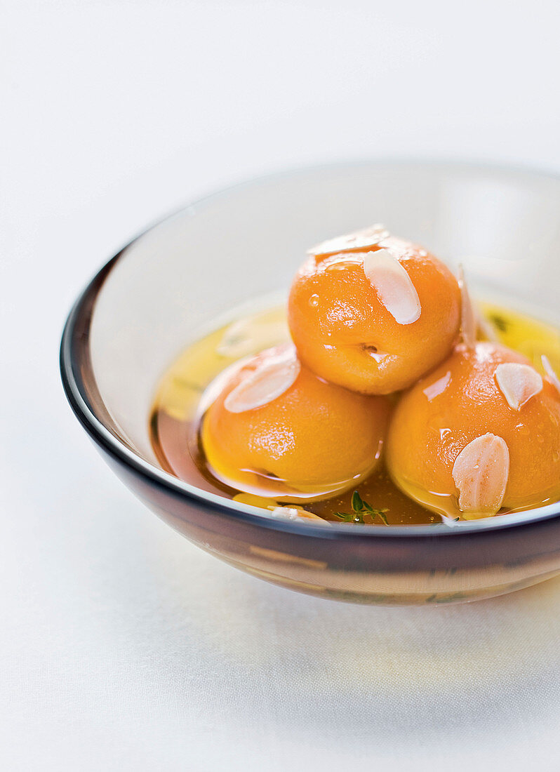 Molecular apricot and olive oil dessert with flaked almonds