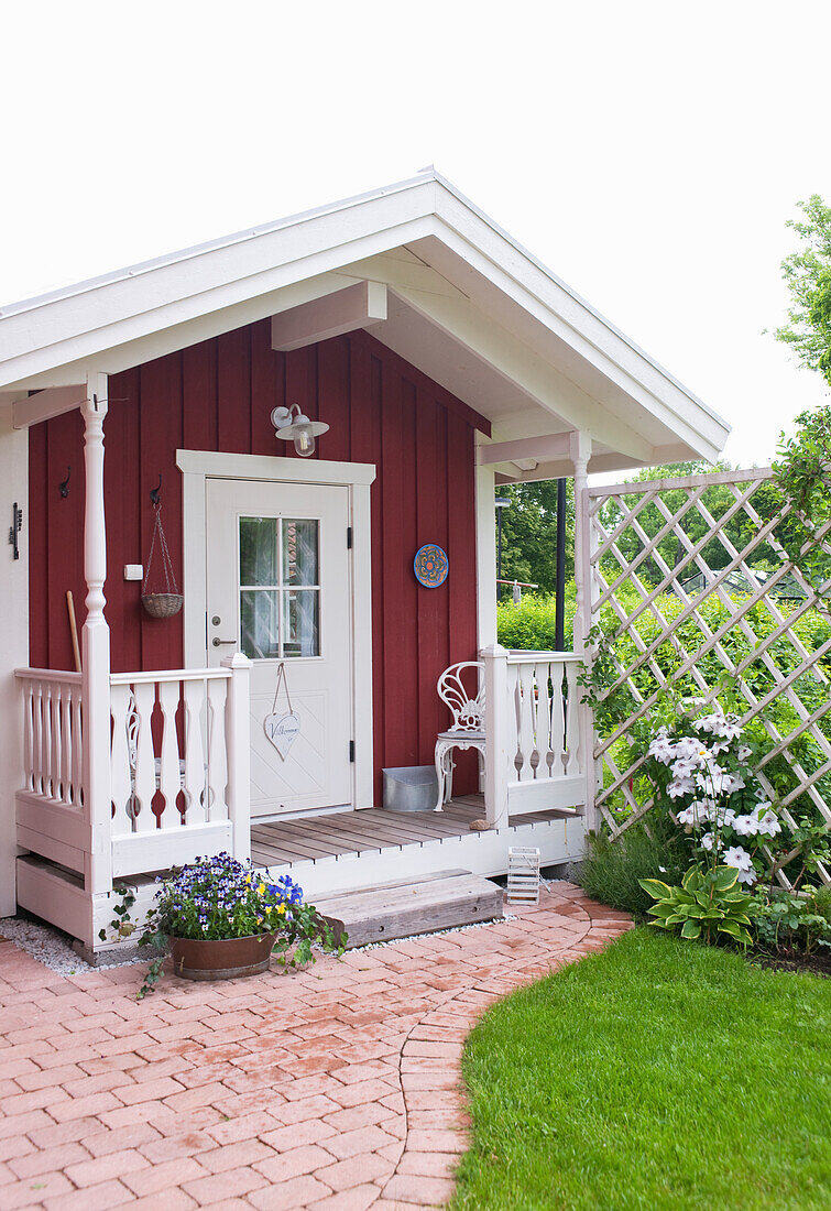 Red-brown wooden house with white veranda