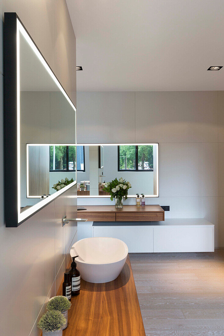 Wooden counter with a vessel sink, wall mirror above in the en-suite bathroom