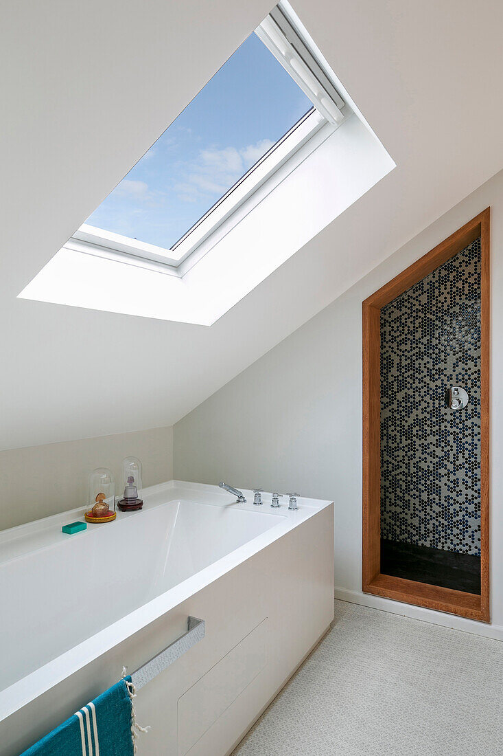 Badezimmer mit Badewanne und Dachflächenfenster