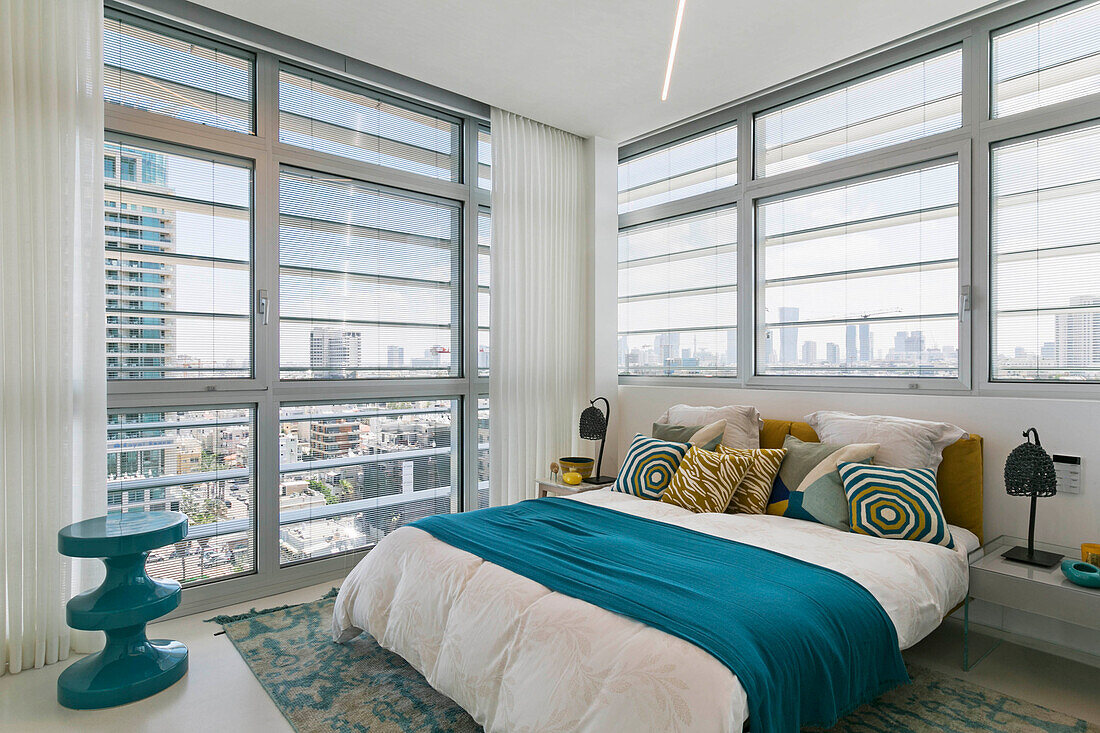 Doppelbett im Schlafzimmer mit raumhohen Fenstern in einem Luxus-Penthouse