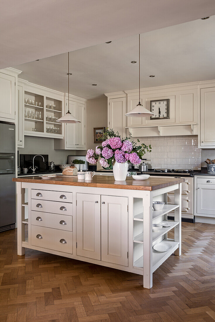 Pink hydrangea on refreshed island unit in Georgian kitchen with parquet floor