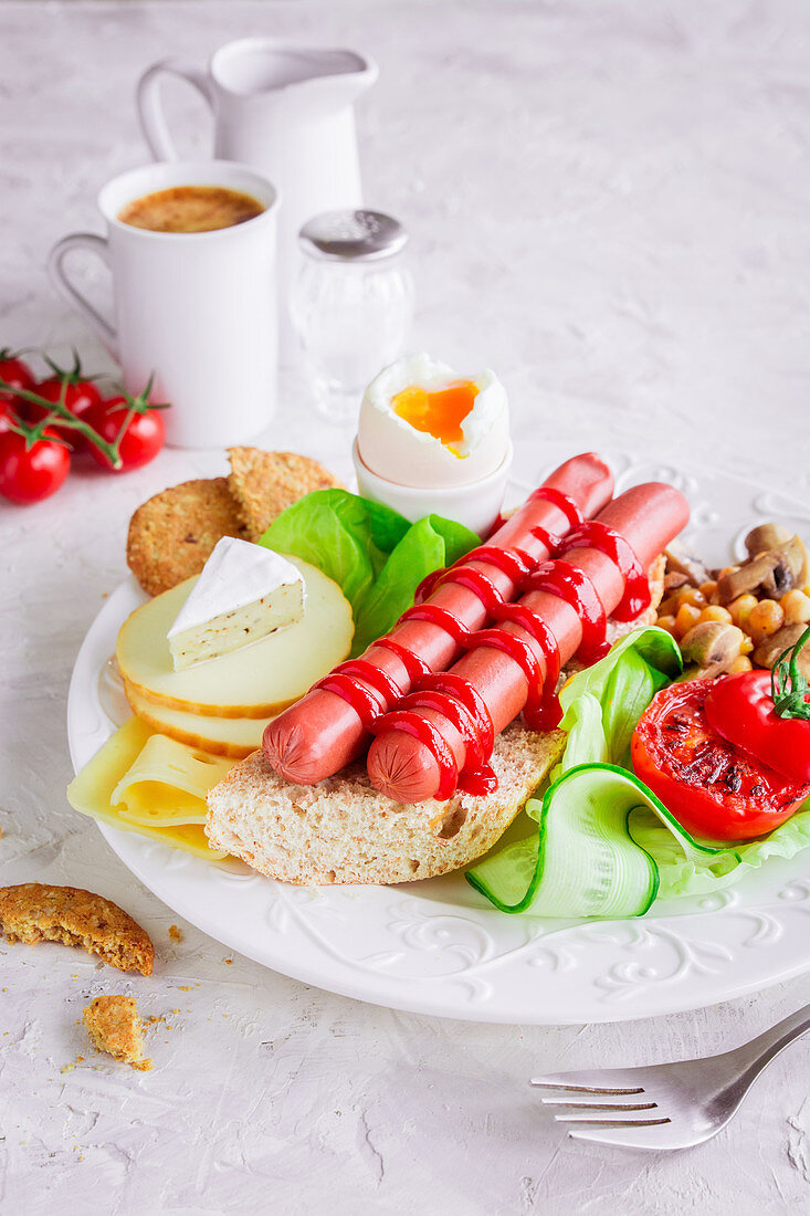Frühstück mit Würstchen, Tomaten, Käse und weichgekochtem Ei