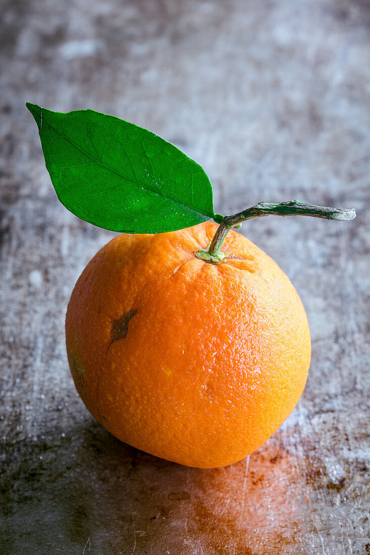 Eine Orange mit Blatt