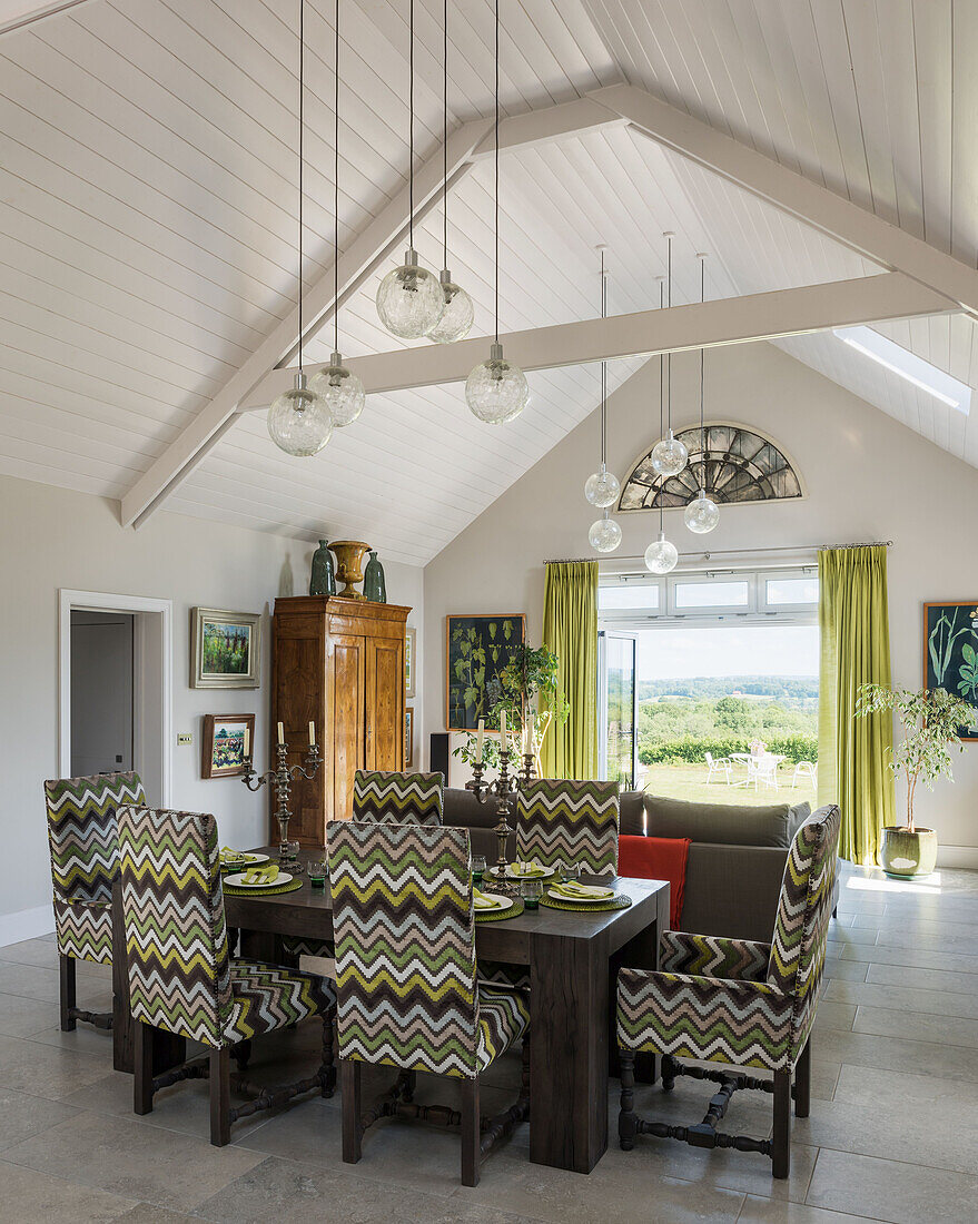 Open plan space with vintage glass globes grouped to define areas and view to south facing terrace