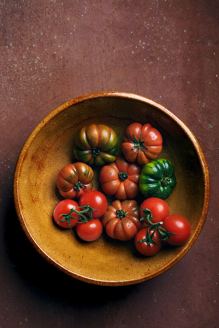 Different tomatoes in earthenware bowl