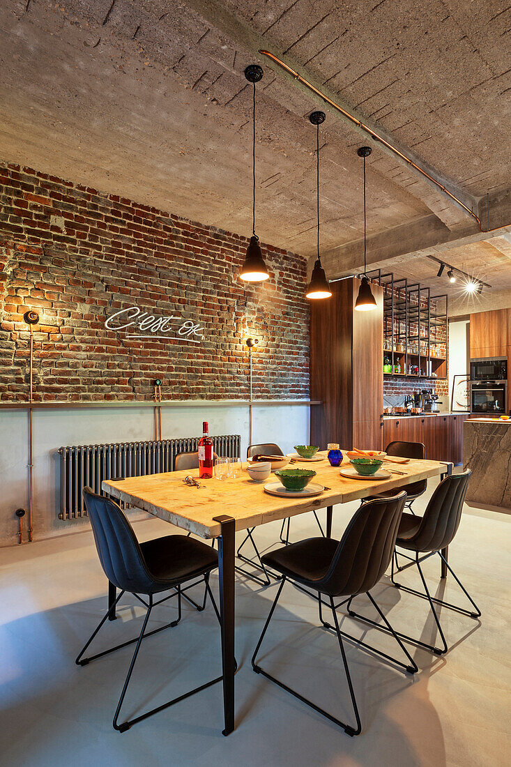 Dining area in front of brick wall in a loft