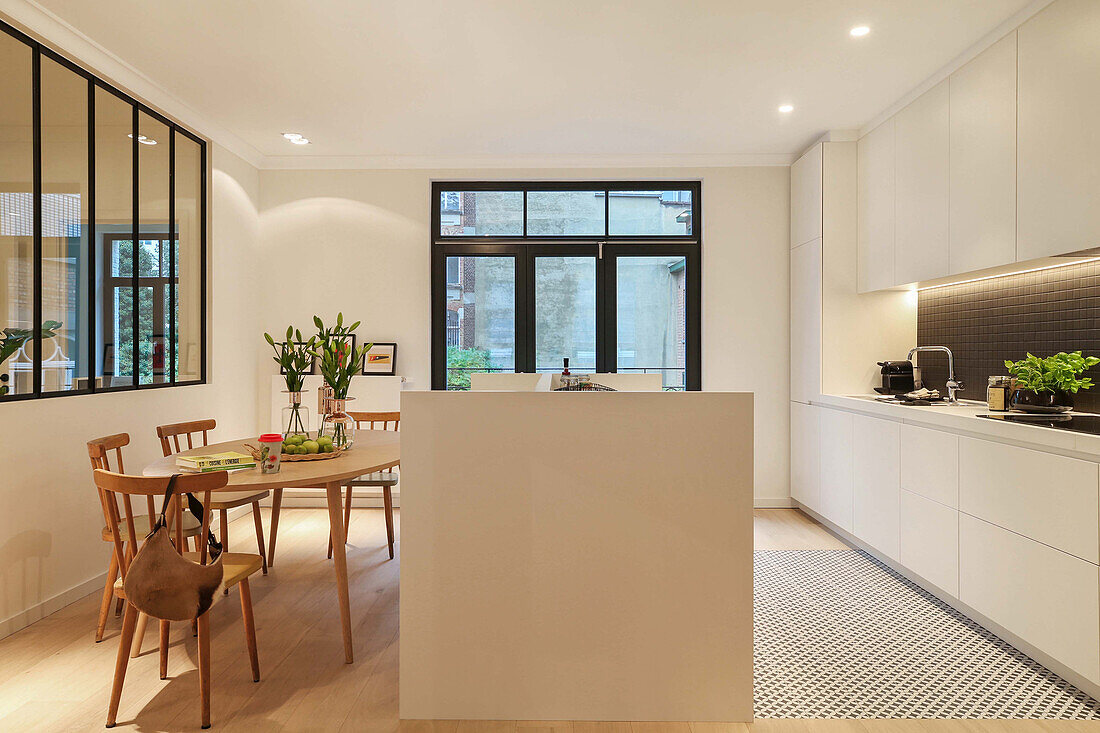 White custom kitchen with island counter and dining area