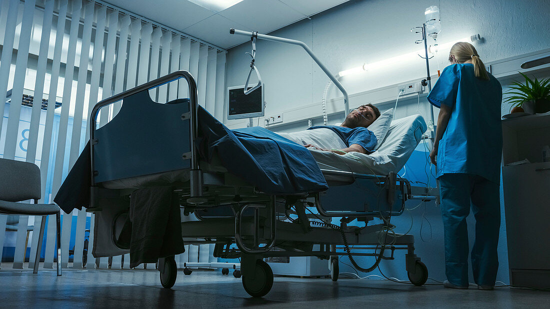 Sick man lying in a hospital bed