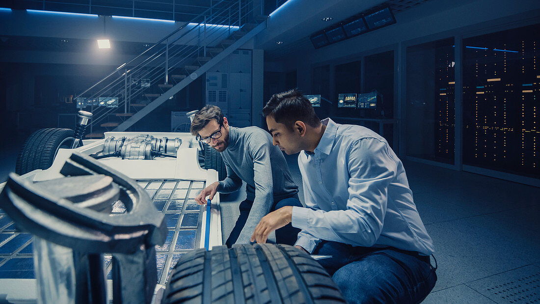 Two automotive engineers working on an electric car