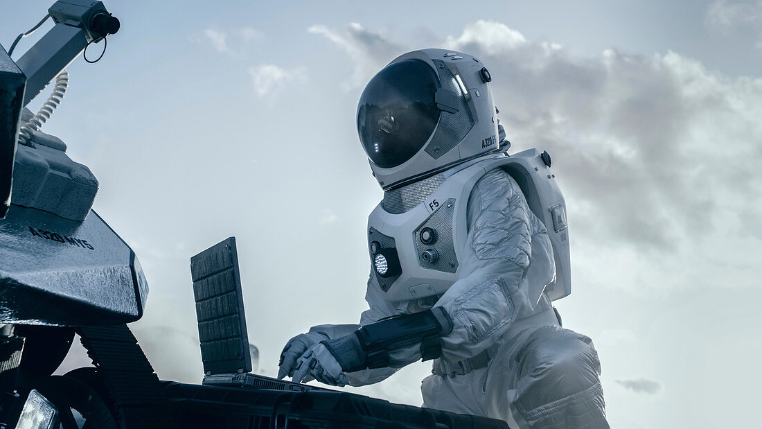 Astronaut using a laptop on an alien planet
