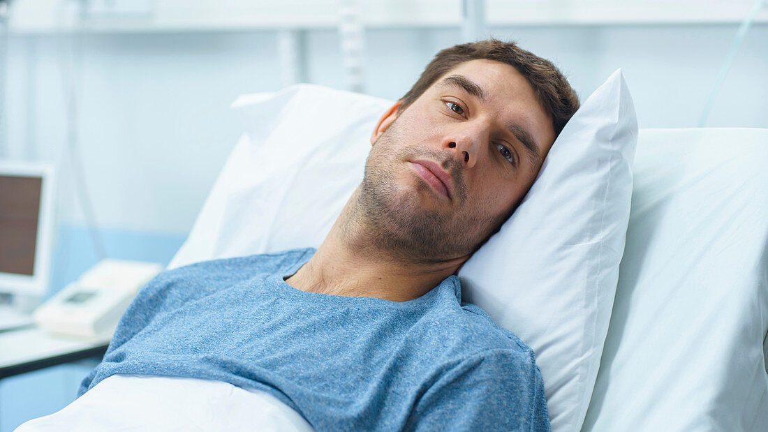 Ill man lying in a hospital bed