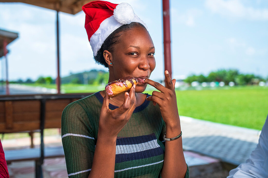 Woman eating dessert in a Santa hat