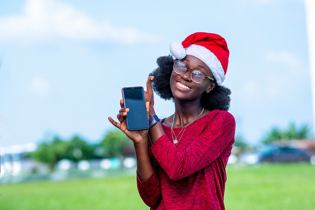 Woman in Santa hat with smartphone