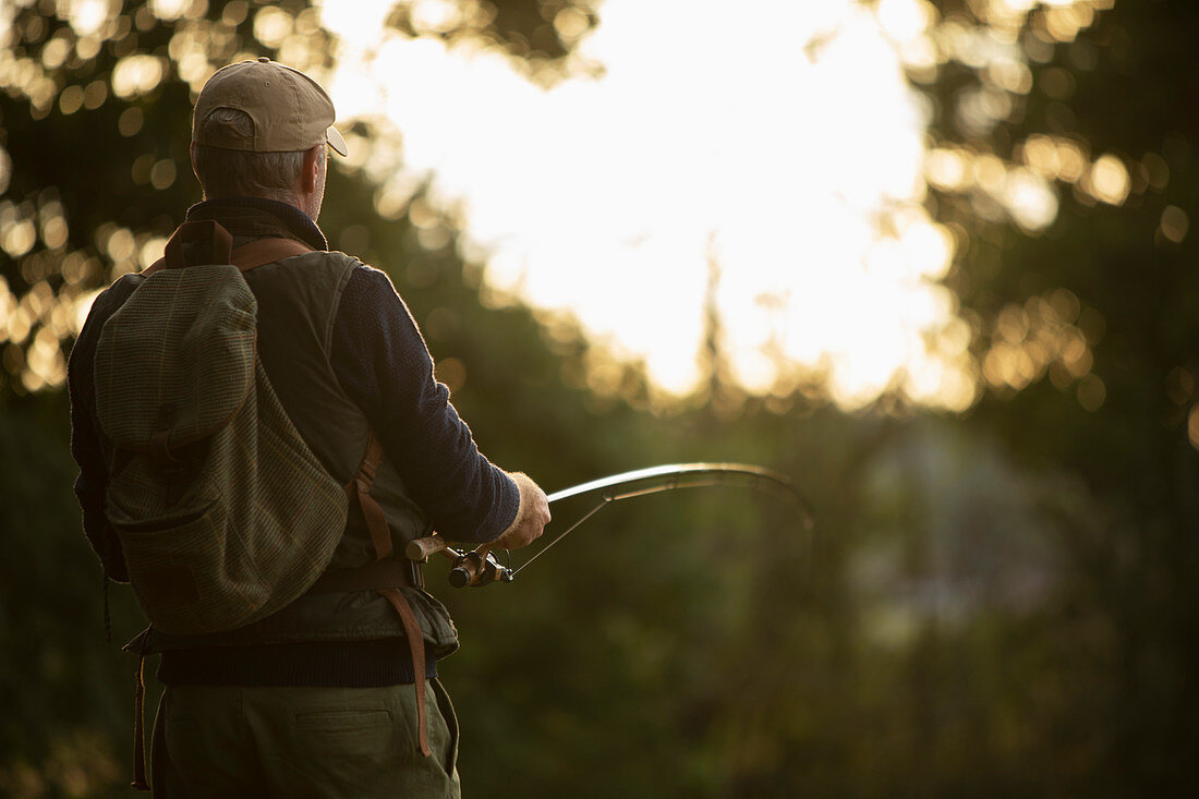 Man with backpack fly fishing