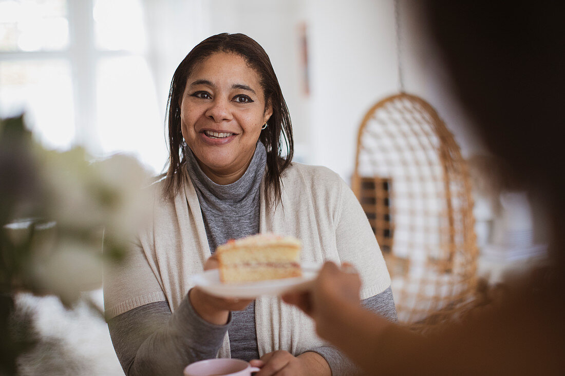 Daughter serving slice of cake to mother