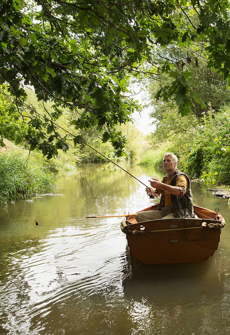 Man fly fishing from boat in river