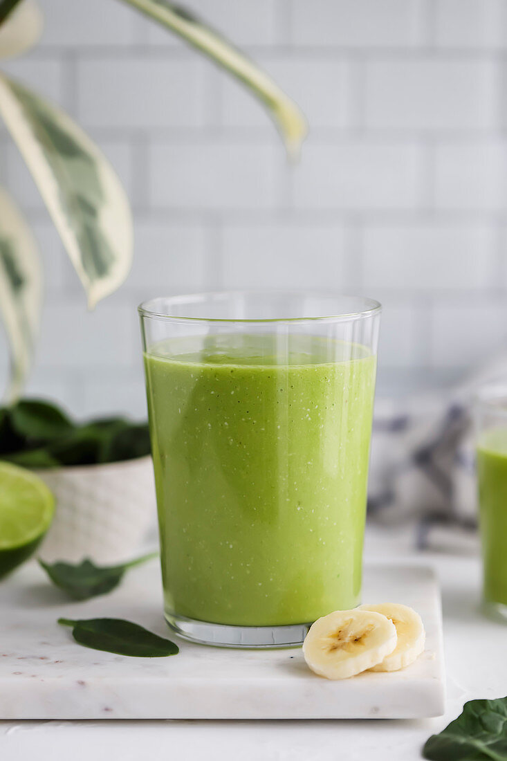 Glass of a green smoothie with fresh fruit