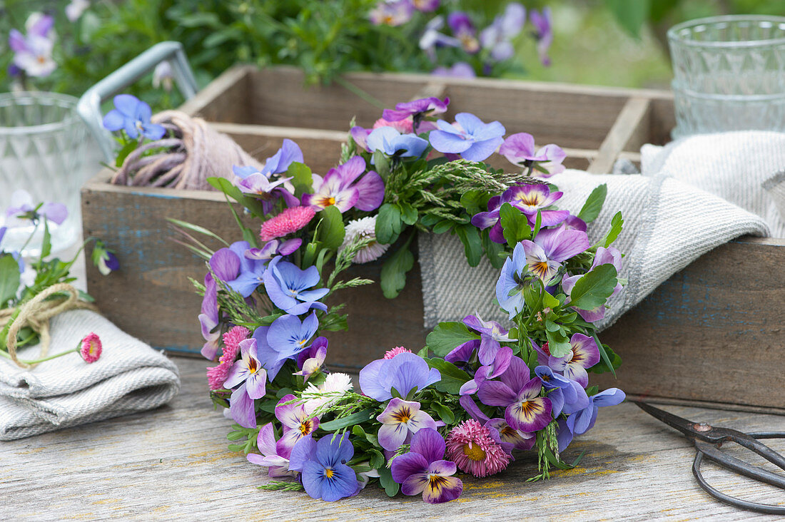 Small wreath of horned violets, daisies and grasses