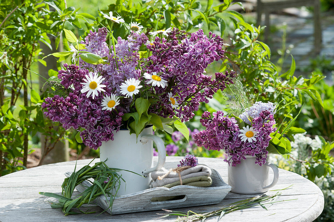 Bouquets of lilacs and daisies in enamelled pots