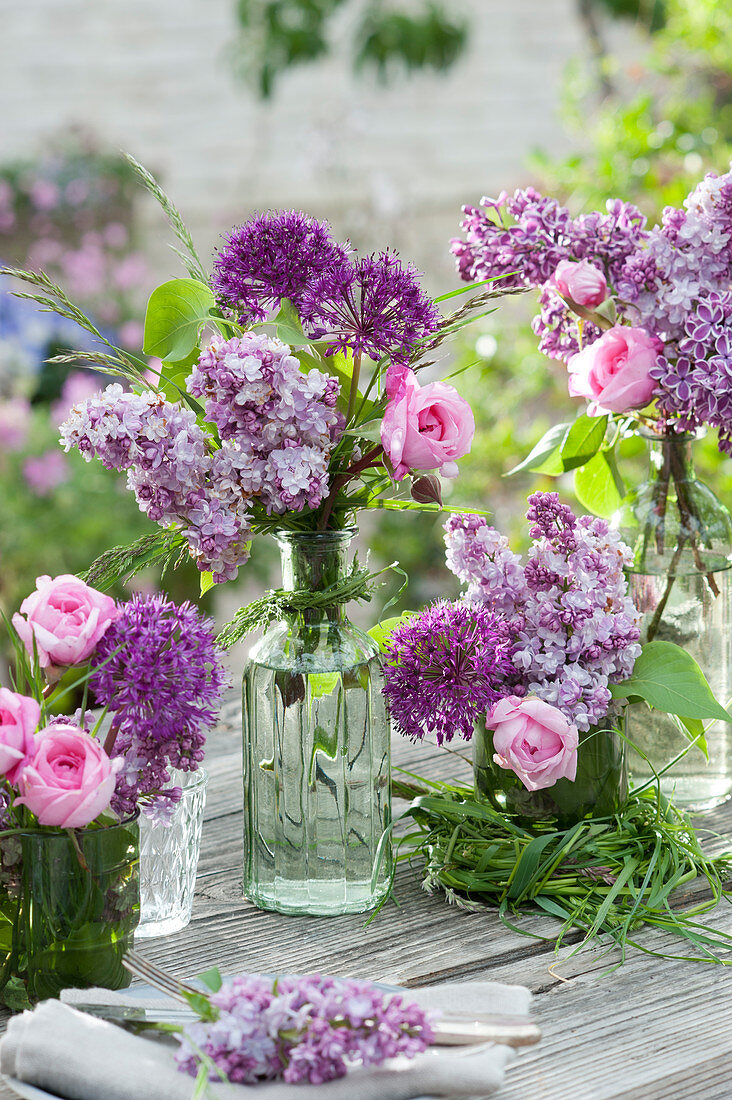 Spring bouquets of lilacs, roses, and allium with grass and a grass wreath