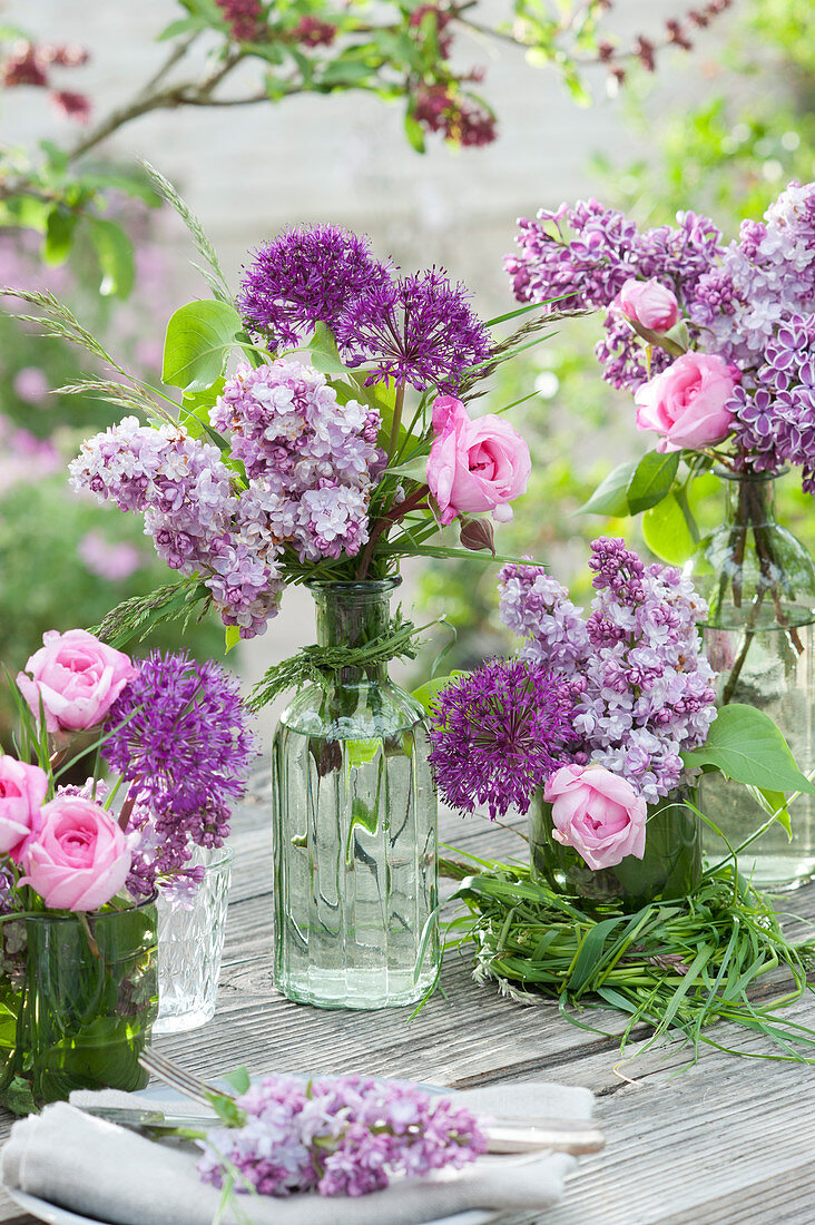 Spring bouquets of lilacs, roses, and allium with grass and a grass wreath