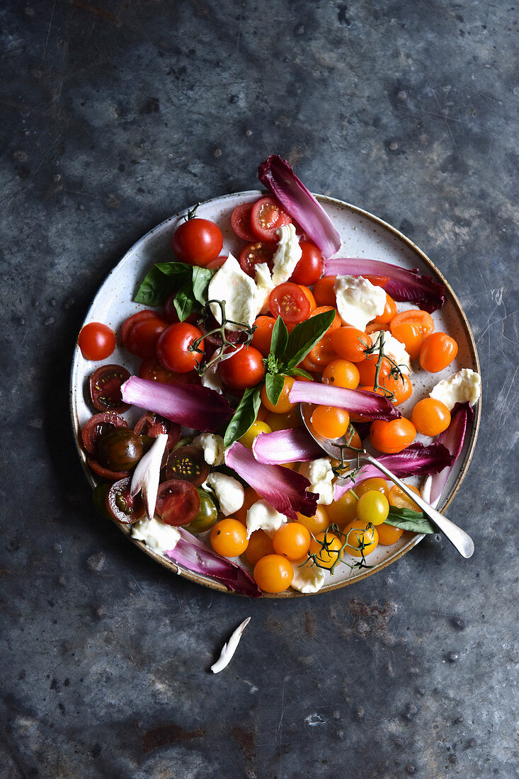 A healthy Tomato Salad against a marble background