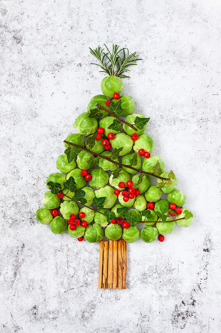 A Christmas Tree made from brussel sprouts and cinnamon sticks and decorated with ivy, berries and rosemary