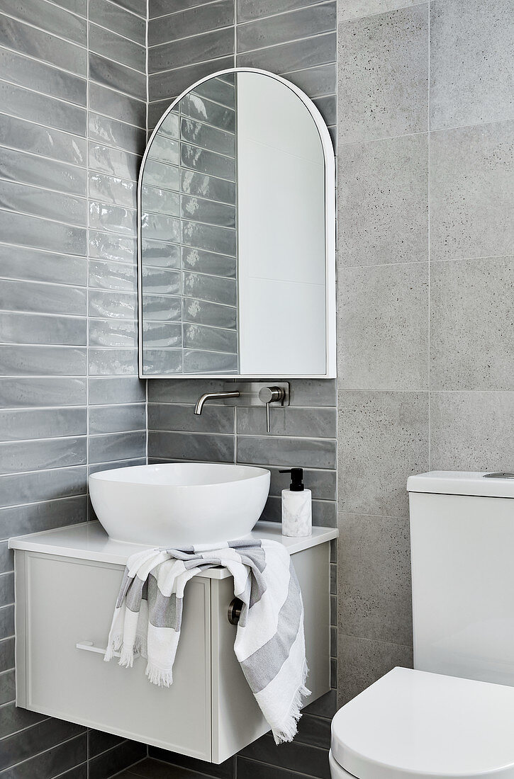 Washstand with countertop sink below mirror