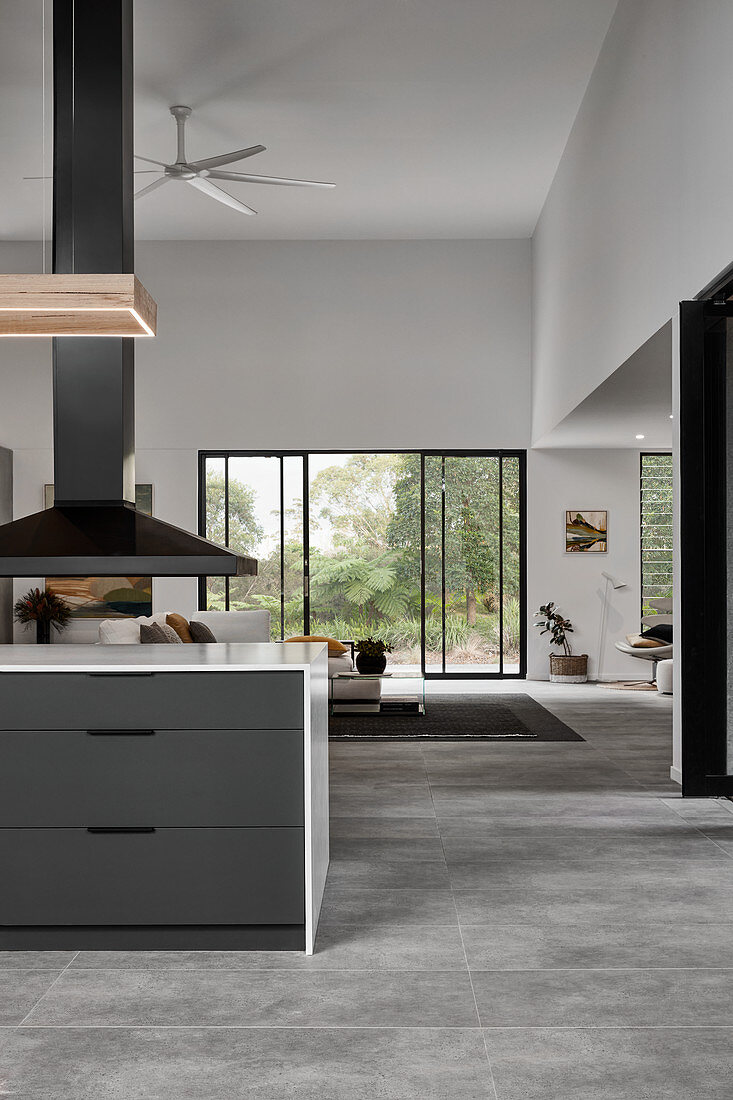 Extractor hood above kitchen island in open-plan interior