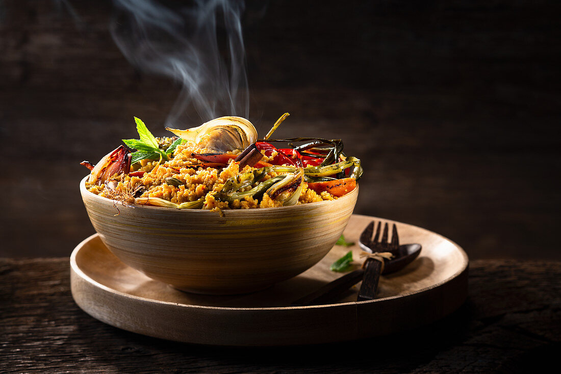 Tunisian couscous dish with vegetables against a dark background