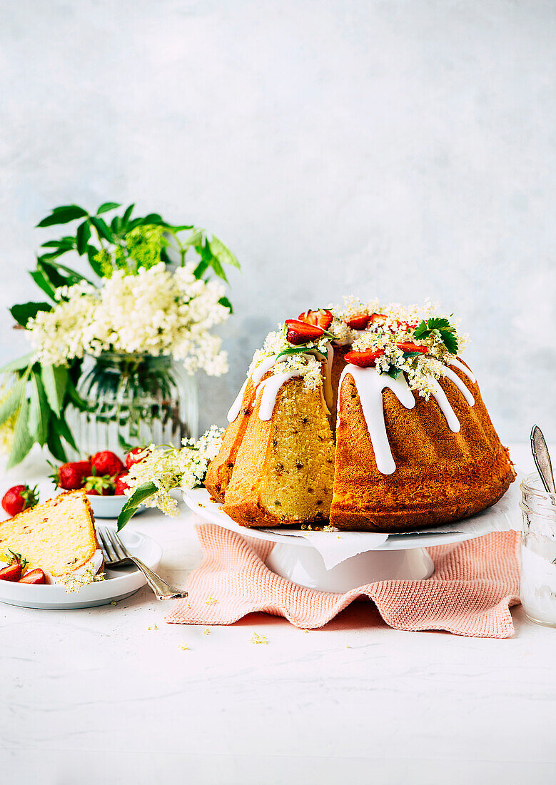 Saftiger Holunderblüten-Guglhupf mit Schokosplittern und Erdbeeren