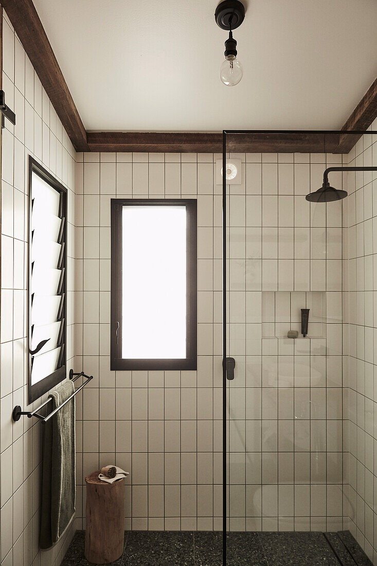 White wall tiles and glass partition in the shower