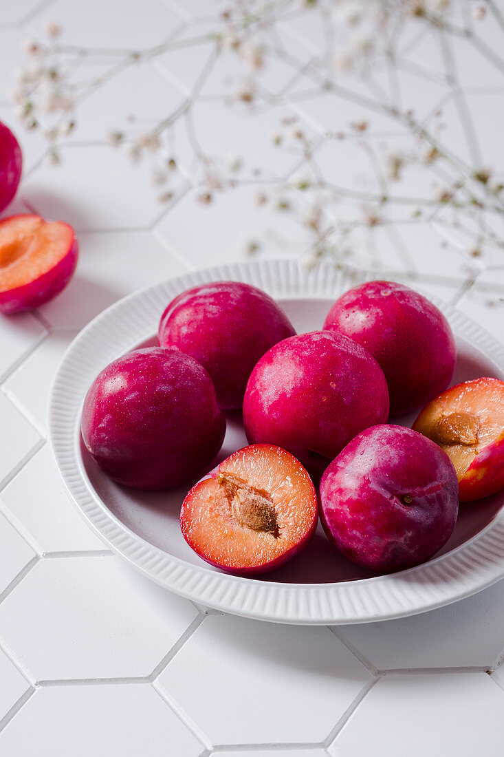 Fresh plums on the white plate
