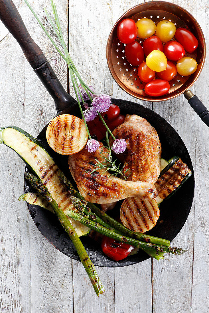 Grilled chicken and vegetables on white wooden table