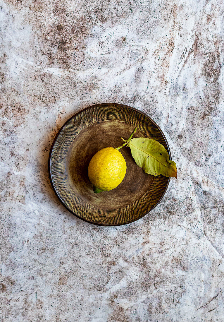 Organic Lemon on textured brown handmade ceramic plate