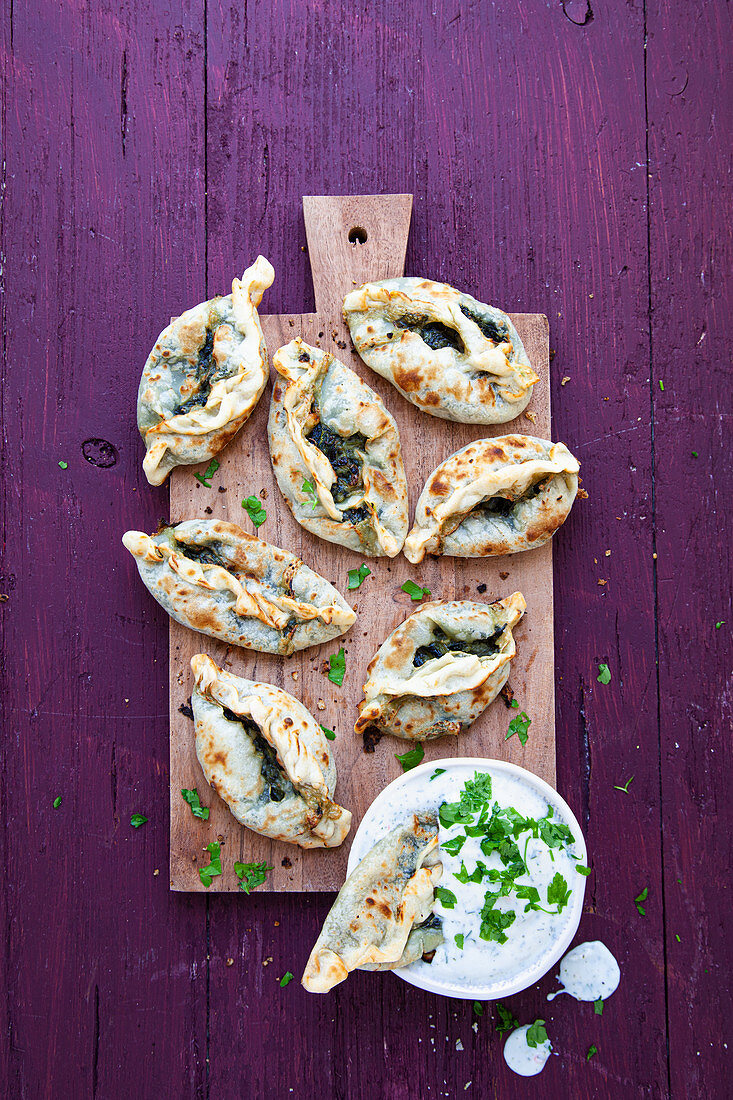 Mini pide (flatbread) with spinach filling and yogurt herb dip