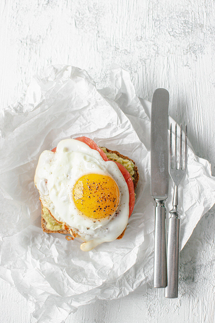 Sandwich with avocado, tomato and fried egg