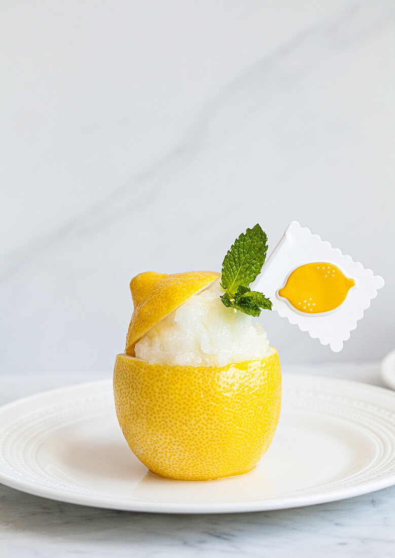 A scooped out lemon half filled with lemon granita