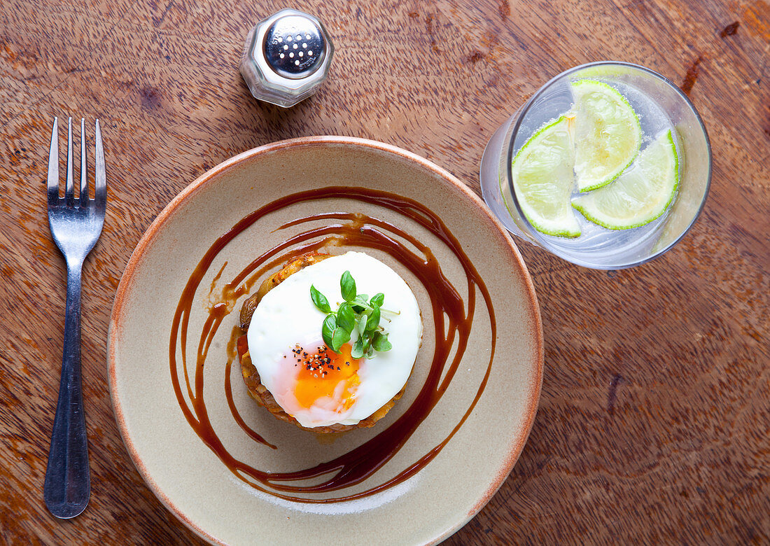 Fried egg on potato rosti with fresh basil and chilli sauce