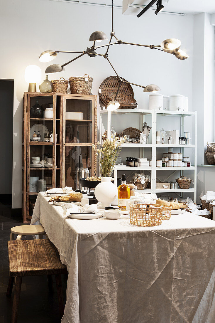 Set table with sand-colored tablecloth in front of showcases