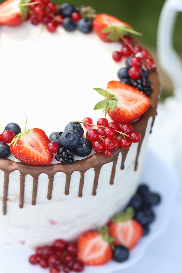 White drip cake with fresh berries