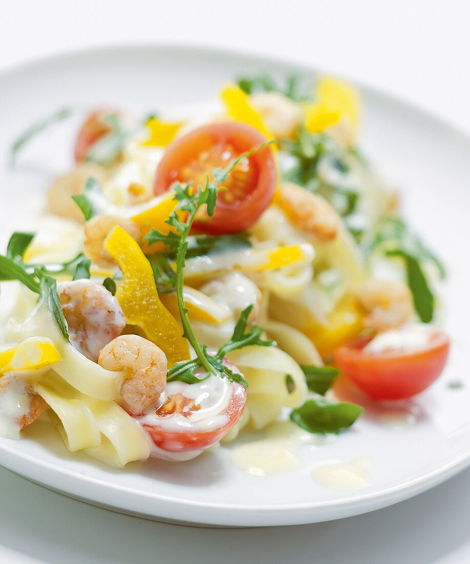 Tagliatelle tossed in a creamy cheese sauce with shrimp, yellow peppers, cherry tomatoes, and arugula