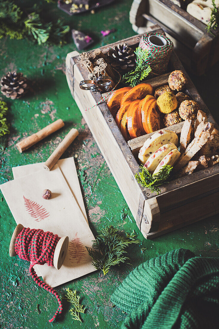 Weihnachtsdekoration und Weihnachtssüßigkeiten in Holzkästchen