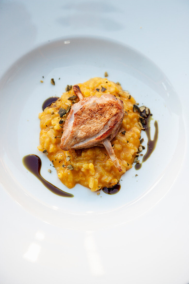 Pumpkin curry risotto with quail lemongrass skewer